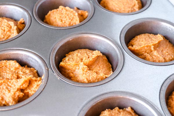 pumpkin batter scooped in a muffin pan