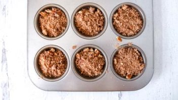 pecan streusel topping next to muffin pan with pumpkin batter inside