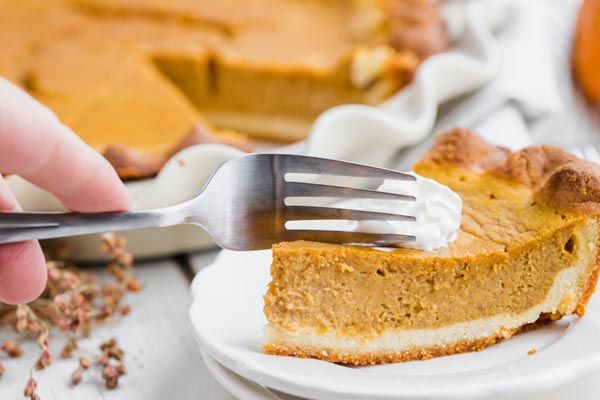 slicing into a pumpkin pie for a bite