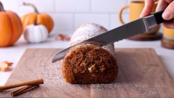 Ketofocus slicing the end off a swiss cake with a serrated knife.