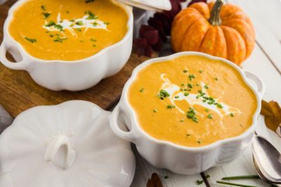 two bowls of low carb pumpkin soup ganished with creme fresh and chives