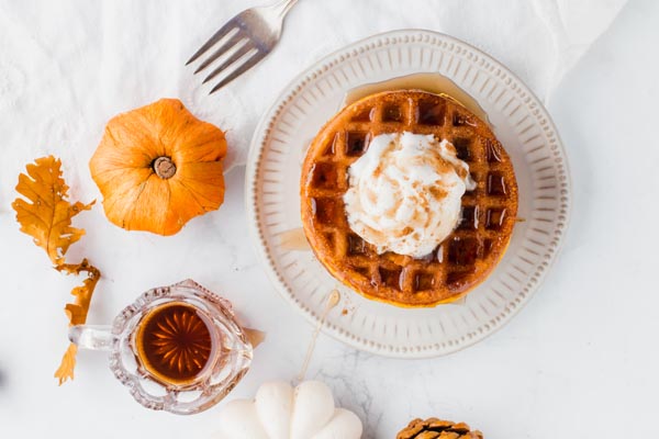 pumpkin chaffle spread on a table with syrup