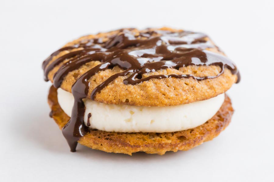a pumpkin whoopie pie with melted chocolate dripping