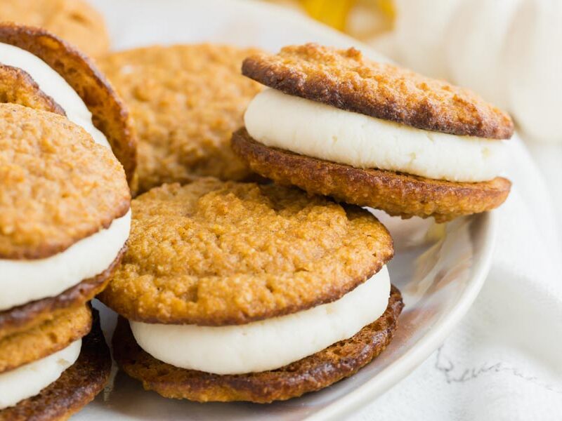 pumpkin whoopie pies filled with a thick layer of cream on a plate