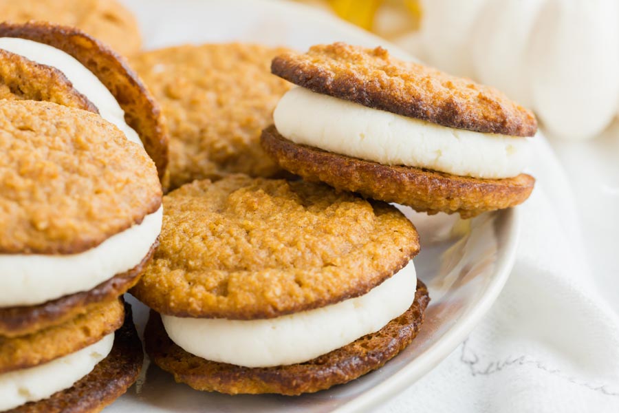 pumpkin whoopie pies filled with a thick layer of cream on a plate