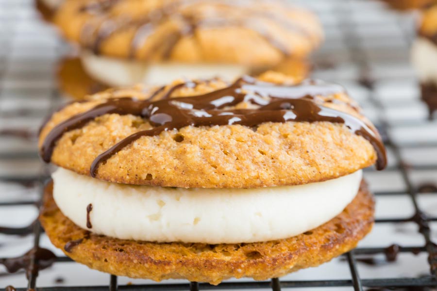 closeup of melted chocolate on top of a pumpkin whoopie pie filled with cream cheese