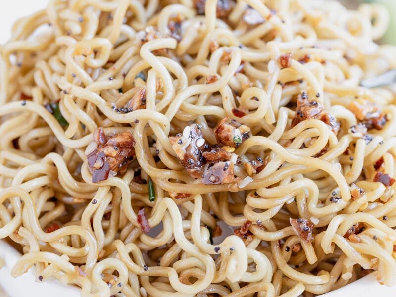 close up of curly keto ramen noodles topped with red pepper flakes and sesame seeds