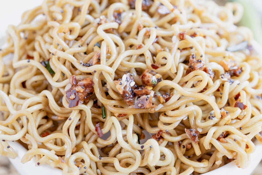 close up of curly keto ramen noodles topped with red pepper flakes and sesame seeds