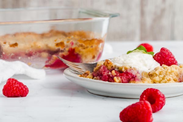 plate of raspberry crumble and baking dish
