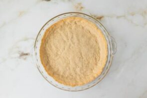 A pressed almond flour crust baked until lightly golden in a glass pie dish.