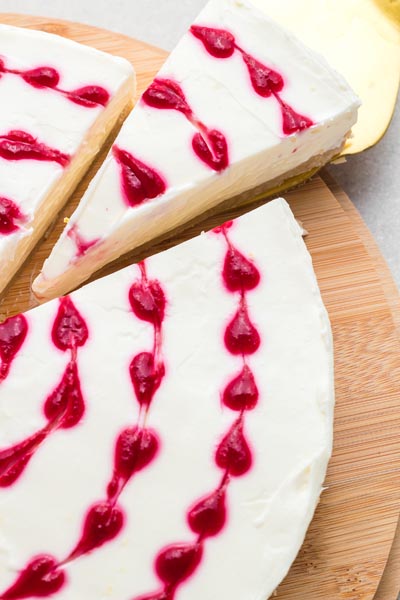 A slice of cheesecake being pulled from the whole cake.