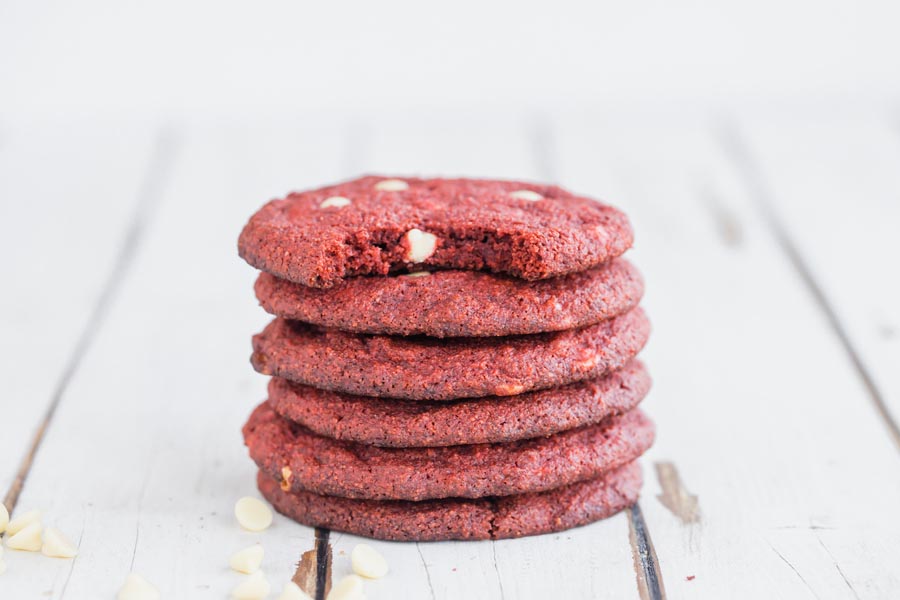 a stack of 6 red velvet cookies with the top one a bite taken out