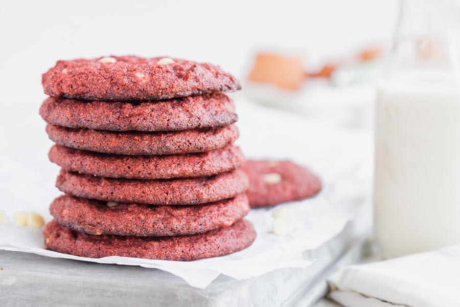 a stack of seven red velvet cookies and a glass of milk