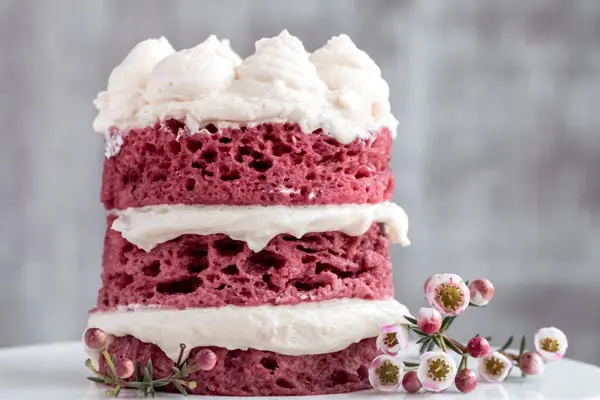 stack of keto red velvet waffles topped with cream cheese frosting on the breakfast table