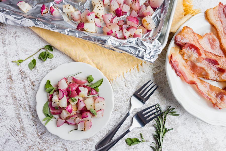 two plates, one with baked radishes and one with bacon