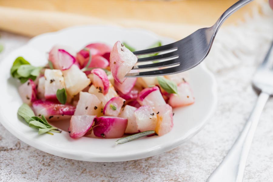 a fork holding a cooked radish