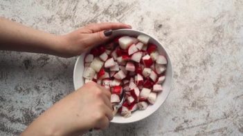 stirring a bowl of diced radishes with a spoon