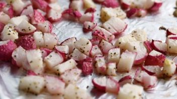 roasted red radishes on a tray sprinkled with pepper