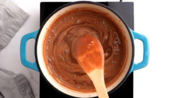 A wooden spoon showing how the chocolate custard mixture has coated the spoon for thickness.