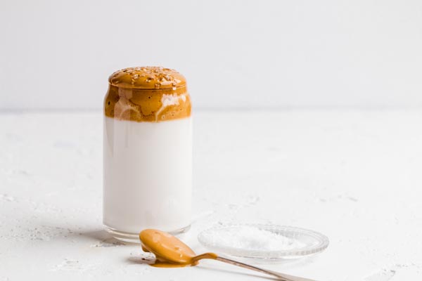 spooning whipped coffee layer onto cold glasses of nut milk