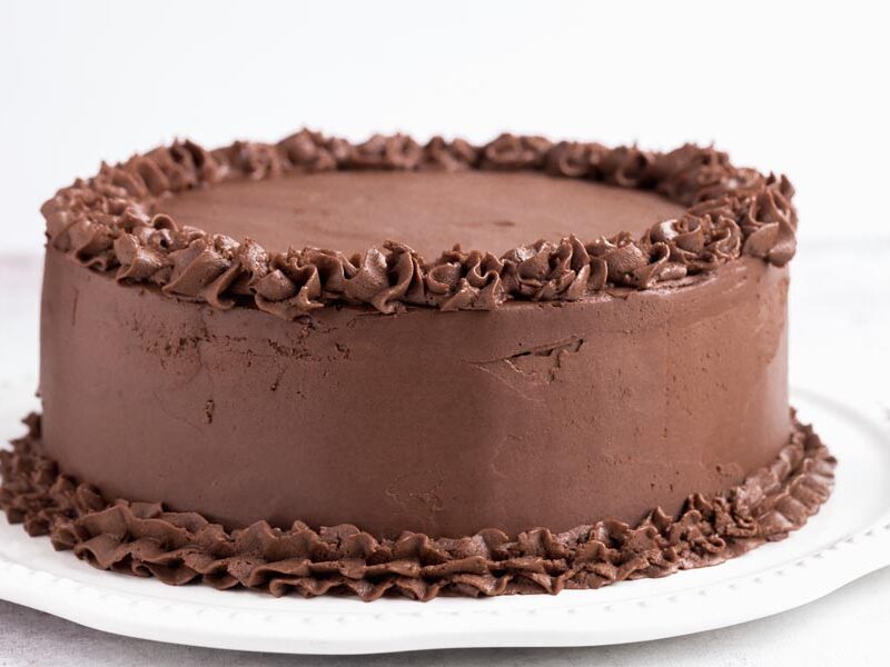 A whole chocolate frosted cake on a platter.
