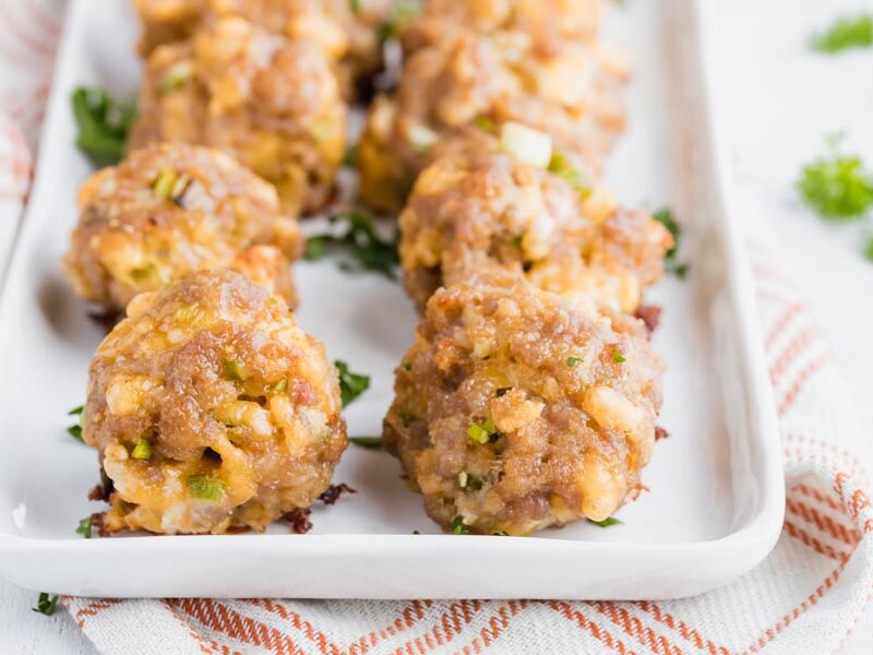a plate with cheddar cheese sausage balls lined up in two rows