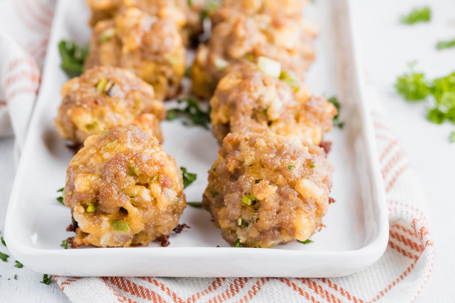 a plate with cheddar cheese sausage balls lined up in two rows