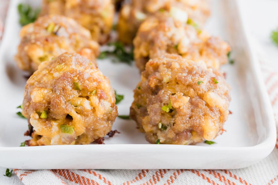 closeup of two sausage balls side by side with melted cheddar cheese coming out