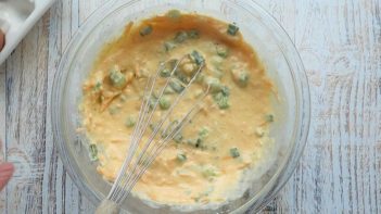 whisking a mixture of egg, cheese and green onion