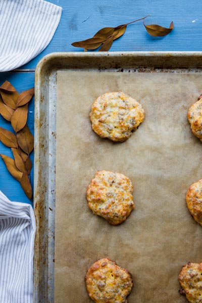 A baking tray with sausage biscuits on it cooling.