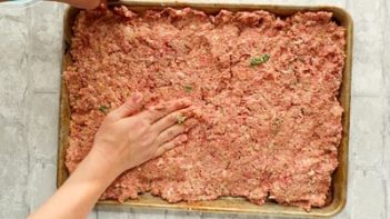 pressing meatloaf into a baking pan