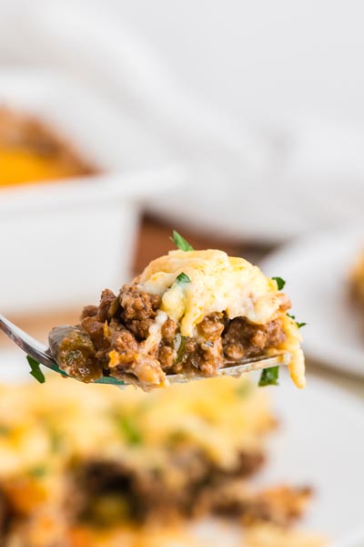 A bite of shepherd's pie resting on a fork.