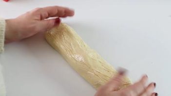 shortbread dough in a log shape wrapped in saran wrap
