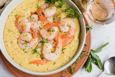 looking onto a large bowl of shrimp and grit sprinkled with black pepper and herbs