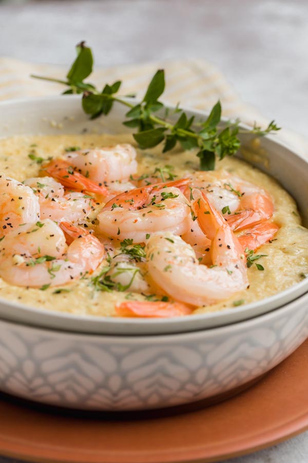 a big bowl of shrimp and grits with thyme on the side