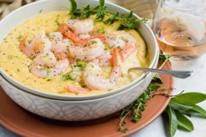 a bowl of shrimp and grits with a spoon in the bowl