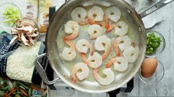 shrimp in a layer cooking in a big skillet