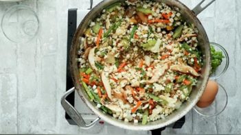 cauliflower rice and veggies cooking in a skillet