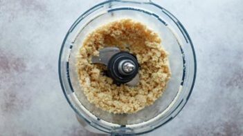 a food processor with a crust grinded into coarse crumbles