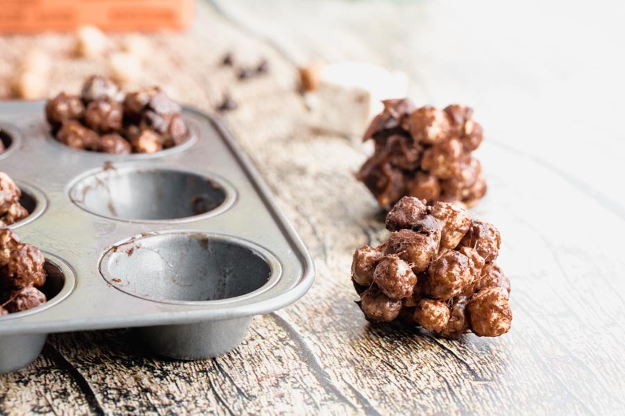 a gooey chocolate smores ball next to a muffin tin