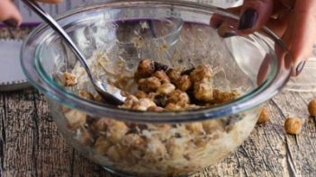 stirring gooey marshmallow mixture with round cereal