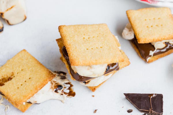 three smores with pieces of chocolate and marshmallow around