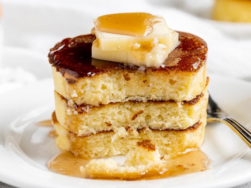 a stack of three pancakes with a bite out of them already