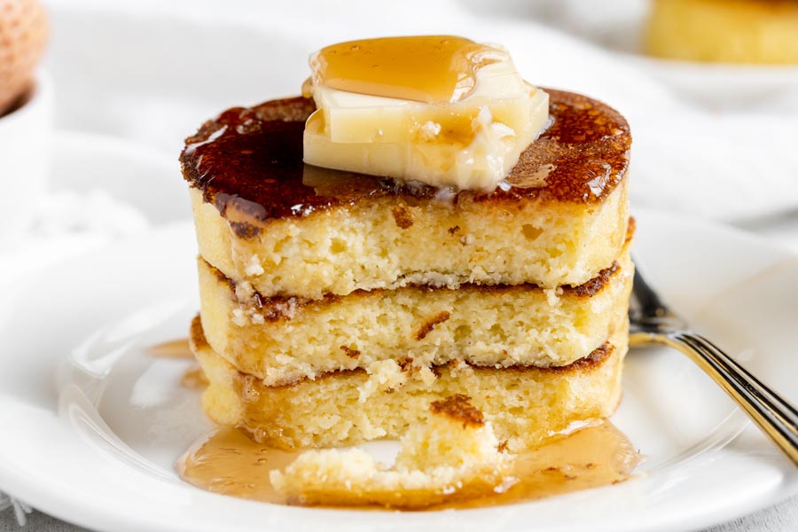 a stack of three pancakes with a bite out of them already