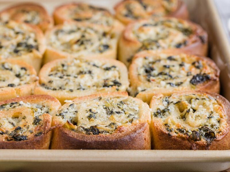 Keto spinach artichoke pinwheels baked in a casserole dish