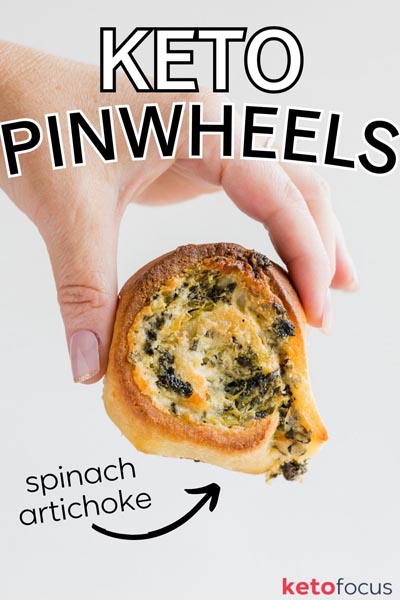 A hand holding a spinach artichoke pinwheel bun.