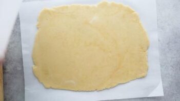 Rolled out keto pastry dough in a rectangle shape on a sheet of parchment paper.
