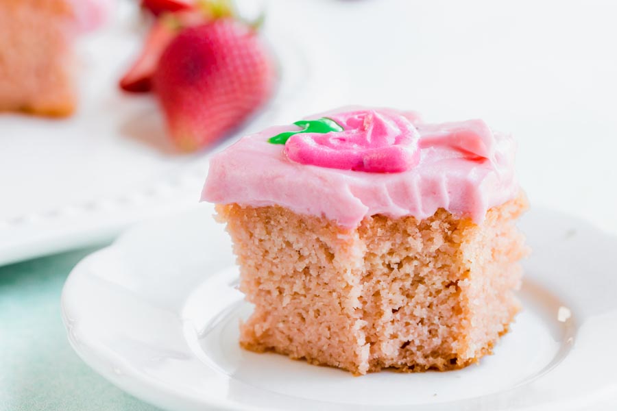 a bite taken out of a slice of pink cake on a plate