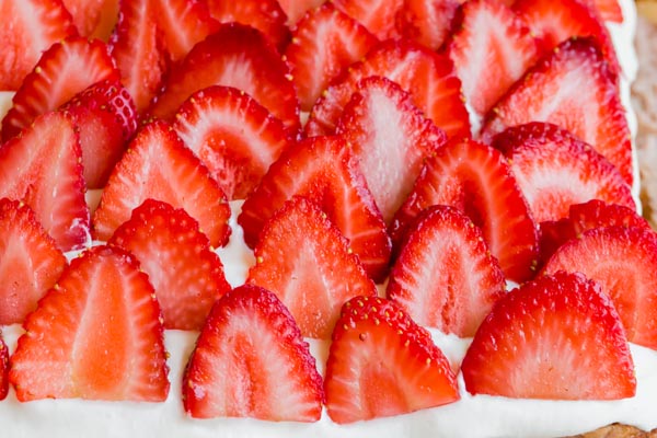 strawberries sliced and sitting on a cake
