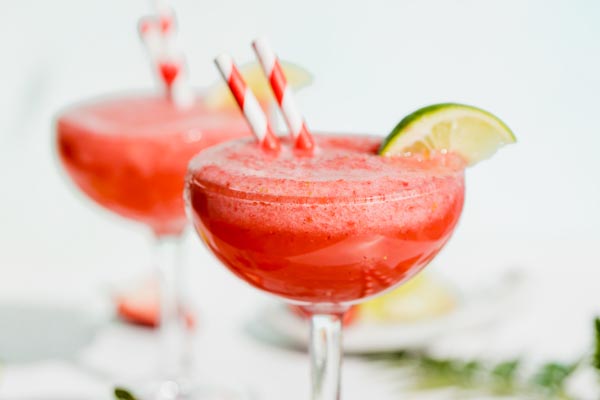 a blended strawberry daiquiri garnished with a lime